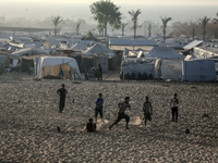 Displaced Palestinians are playing football next to their tents in Khan Younis, in the southern Gaza Strip, on May 3, 2024, amid the ongoing...