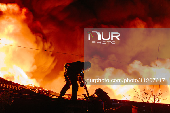 Firefighters are extinguishing the fire at the site of the drone attack in Kharkiv, Ukraine, on May 4, 2024. On the night of May 4, Russia a...