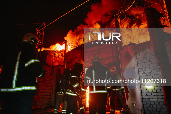 Firefighters are extinguishing the fire at the site of the drone attack in Kharkiv, Ukraine, on May 4, 2024. On the night of May 4, Russia a...