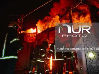 Firefighters are extinguishing the fire at the site of the drone attack in Kharkiv, Ukraine, on May 4, 2024. On the night of May 4, Russia a...