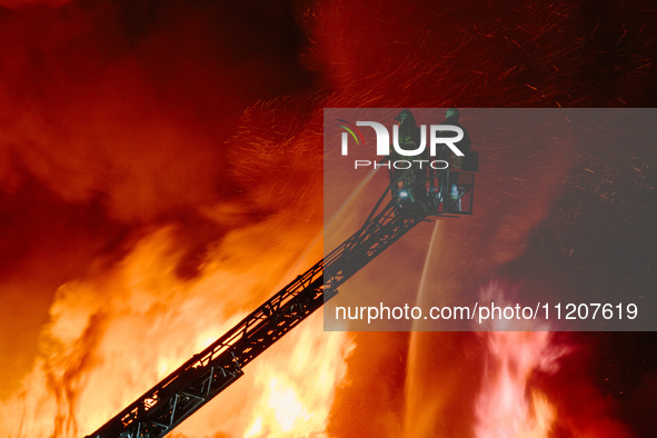 Firefighters are extinguishing the fire at the site of the drone attack in Kharkiv, Ukraine, on May 4, 2024. On the night of May 4, Russia a...