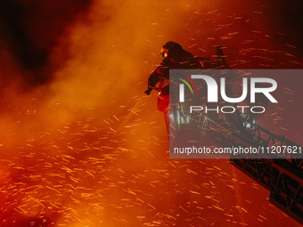 Firefighters are extinguishing the fire at the site of the drone attack in Kharkiv, Ukraine, on May 4, 2024. On the night of May 4, Russia a...