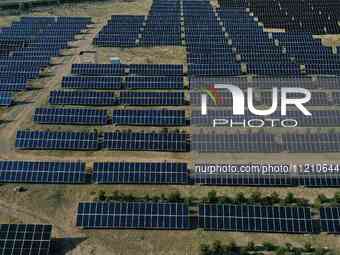 A drone is capturing images of photovoltaic power stations on both sides of the Beijing-Wei Expressway in Zhangjiakou, Hebei Province, China...