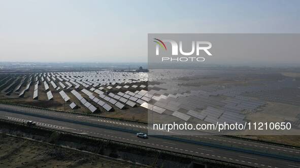 A drone is capturing images of photovoltaic power stations on both sides of the Beijing-Wei Expressway in Zhangjiakou, Hebei Province, China...