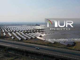 A drone is capturing images of photovoltaic power stations on both sides of the Beijing-Wei Expressway in Zhangjiakou, Hebei Province, China...