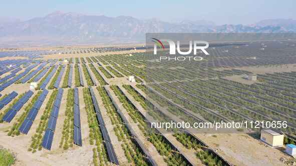 A drone is capturing images of photovoltaic power stations on both sides of the Beijing-Wei Expressway in Zhangjiakou, Hebei Province, China...