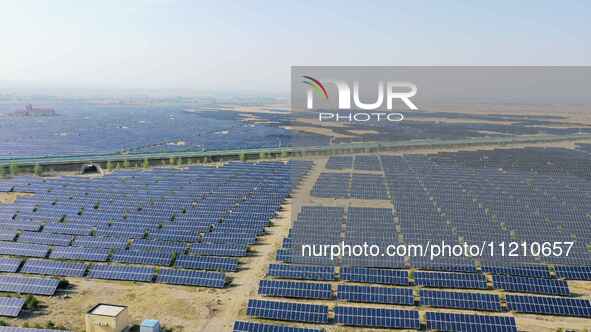 A drone is capturing images of photovoltaic power stations on both sides of the Beijing-Wei Expressway in Zhangjiakou, Hebei Province, China...