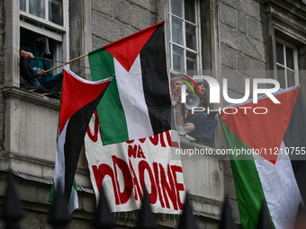 DUBLIN, IRELAND - MAY 4:
Trinity College Dublin windows occupied by students in Keffiyeh and face masks, waving Palestinian flags, on May 4,...