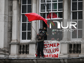 DUBLIN, IRELAND - MAY 4:
Trinity College Dublin windows occupied by students in Keffiyeh and face masks, waving Palestinian flags, on May 4,...