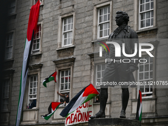 DUBLIN, IRELAND - MAY 4:
Trinity College Dublin windows occupied by students in Keffiyeh and face masks, waving Palestinian flags, on May 4,...