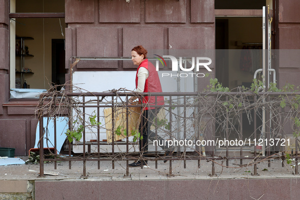 A woman is standing outside a building that has been damaged by Russian shelling in Kharkiv, Ukraine, on May 5, 2024. 