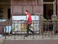 A woman is standing outside a building that has been damaged by Russian shelling in Kharkiv, Ukraine, on May 5, 2024. (