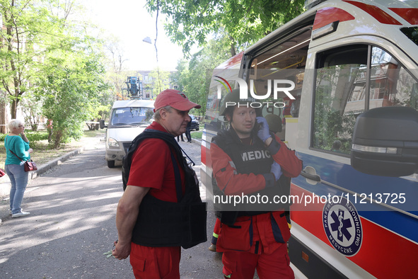 A medic is talking on the phone outside a building damaged by Russian shelling in Kharkiv, Ukraine, on May 5, 2024. NO USE RUSSIA. NO USE BE...