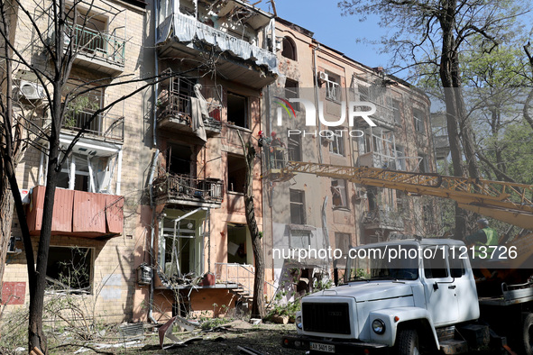 Municipal workers are cutting down a tree outside an apartment block that was damaged by Russian shelling in Kharkiv, northeastern Ukraine,...