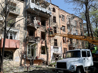 Municipal workers are cutting down a tree outside an apartment block that was damaged by Russian shelling in Kharkiv, northeastern Ukraine,...