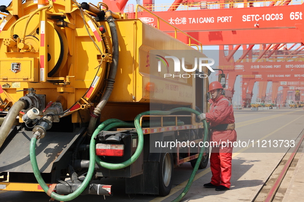 A worker is operating a machine at Taicang Port and the International Port to remove pollutants in Suzhou, Jiangsu Province, China, on March...