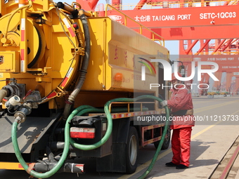 A worker is operating a machine at Taicang Port and the International Port to remove pollutants in Suzhou, Jiangsu Province, China, on March...