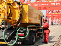 A worker is operating a machine at Taicang Port and the International Port to remove pollutants in Suzhou, Jiangsu Province, China, on March...