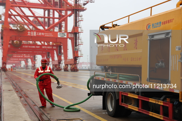 A worker is operating a machine at Taicang Port and the International Port to remove pollutants in Suzhou, Jiangsu Province, China, on March...