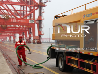 A worker is operating a machine at Taicang Port and the International Port to remove pollutants in Suzhou, Jiangsu Province, China, on March...