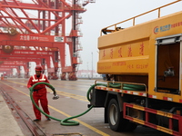 A worker is operating a machine at Taicang Port and the International Port to remove pollutants in Suzhou, Jiangsu Province, China, on March...