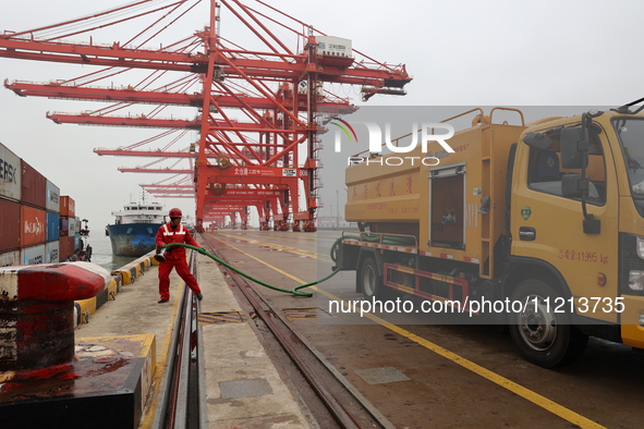 A worker is operating a machine at Taicang Port and the International Port to remove pollutants in Suzhou, Jiangsu Province, China, on March...