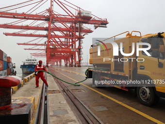 A worker is operating a machine at Taicang Port and the International Port to remove pollutants in Suzhou, Jiangsu Province, China, on March...