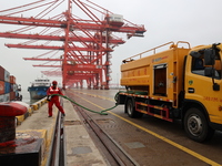 A worker is operating a machine at Taicang Port and the International Port to remove pollutants in Suzhou, Jiangsu Province, China, on March...