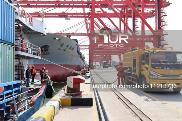 A worker is operating a machine at Taicang Port and the International Port to remove pollutants in Suzhou, Jiangsu Province, China, on March...