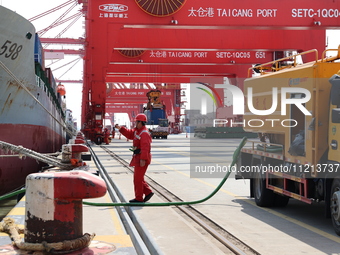 A worker is operating a machine at Taicang Port and the International Port to remove pollutants in Suzhou, Jiangsu Province, China, on March...