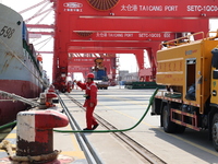 A worker is operating a machine at Taicang Port and the International Port to remove pollutants in Suzhou, Jiangsu Province, China, on March...