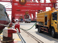 A worker is operating a machine at Taicang Port and the International Port to remove pollutants in Suzhou, Jiangsu Province, China, on March...