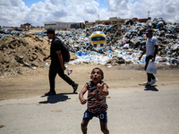 A Palestinian boy is playing next to piles of garbage amid the ongoing conflict in Gaza between Israel and Hamas in Deir Al-Balah, in the ce...