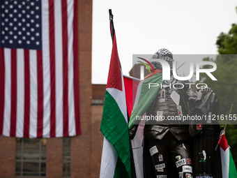 The statue of George Washington at the university that bears his name wears Palestinian flags, kefiyeh and stickers in a Gaza solidarity enc...