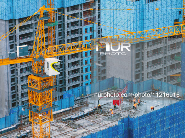 Workers are working at the real estate construction site of a resettlement housing project along the Beijing-Hangzhou Grand Canal in Huai'an...