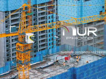 Workers are working at the real estate construction site of a resettlement housing project along the Beijing-Hangzhou Grand Canal in Huai'an...