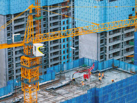 Workers are working at the real estate construction site of a resettlement housing project along the Beijing-Hangzhou Grand Canal in Huai'an...