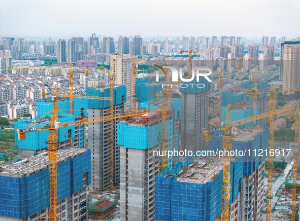 Workers are working at the real estate construction site of a resettlement housing project along the Beijing-Hangzhou Grand Canal in Huai'an...