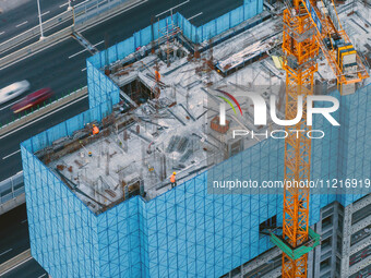 Workers are working at the real estate construction site of a resettlement housing project along the Beijing-Hangzhou Grand Canal in Huai'an...