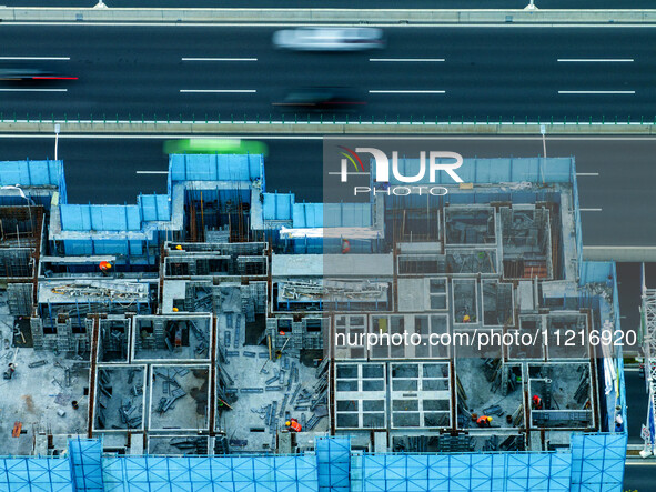 Workers are working at the real estate construction site of a resettlement housing project along the Beijing-Hangzhou Grand Canal in Huai'an...