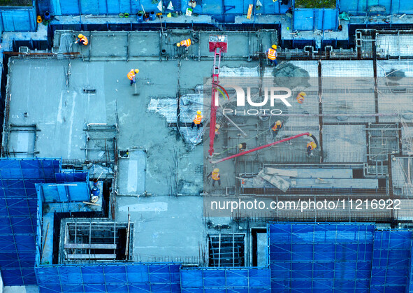 Workers are working at the real estate construction site of a resettlement housing project along the Beijing-Hangzhou Grand Canal in Huai'an...