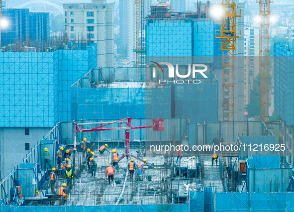 Workers are working at the real estate construction site of a resettlement housing project along the Beijing-Hangzhou Grand Canal in Huai'an...