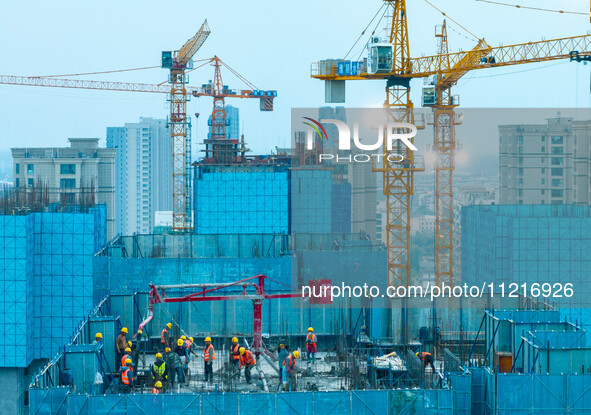 Workers are working at the real estate construction site of a resettlement housing project along the Beijing-Hangzhou Grand Canal in Huai'an...