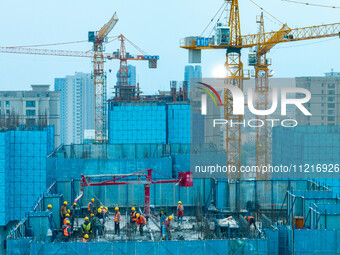 Workers are working at the real estate construction site of a resettlement housing project along the Beijing-Hangzhou Grand Canal in Huai'an...