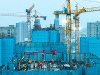 Workers are working at the real estate construction site of a resettlement housing project along the Beijing-Hangzhou Grand Canal in Huai'an...