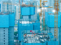 Workers are working at the real estate construction site of a resettlement housing project along the Beijing-Hangzhou Grand Canal in Huai'an...