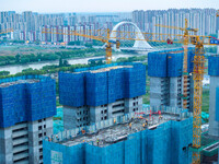 Workers are working at the real estate construction site of a resettlement housing project along the Beijing-Hangzhou Grand Canal in Huai'an...