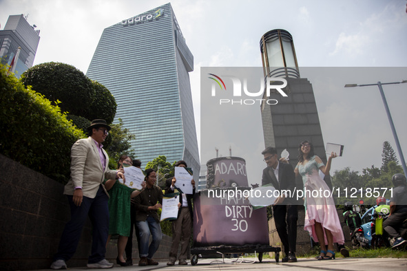 Environmental activists from Enter Nusantara, Market Force, and Greenpeace Indonesia, who are part of the Civil Society Coalition, are perfo...