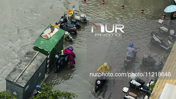 Cars are wading through a flooded road amid an orange rainstorm alert in Nanning, Guangxi Province, China, on May 8, 2024. 