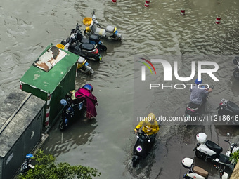 Cars are wading through a flooded road amid an orange rainstorm alert in Nanning, Guangxi Province, China, on May 8, 2024. (